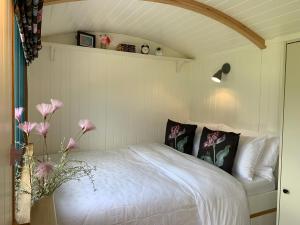 韦德布里奇St. Kew Shepherd Huts的一间卧室,床上有粉红色的鲜花