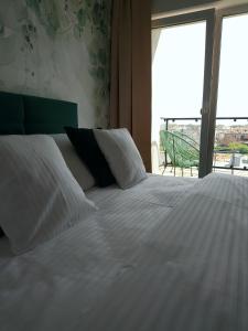 亚斯塔尔尼亚Apartamenty Mistral的卧室设有一张大白色床和阳台