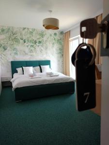 亚斯塔尔尼亚Apartamenty Mistral的一间卧室配有一张铺有绿色地毯的床