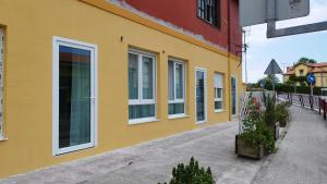 VargasApartamentos y estudios EL CENTRO的街道上一座黄色建筑,设有白色窗户
