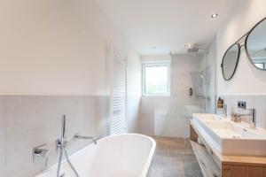 隆高地区圣玛格丽滕Löckerwirt的白色的浴室设有2个盥洗盆和1个浴缸。