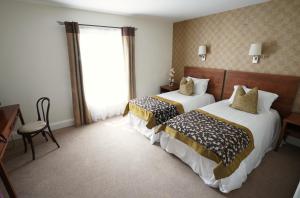 马拉费尔特The Castledawson Inn的酒店客房设有两张床和窗户。