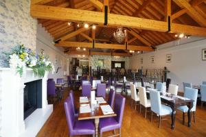 马拉费尔特The Castledawson Inn的一间带桌子和紫色椅子的用餐室