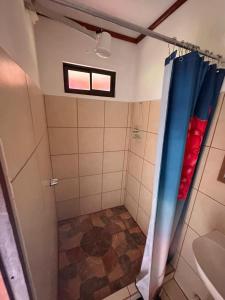 HorquetasRIVER SIDE LODGE的浴室设有蓝色和红色窗帘和淋浴。