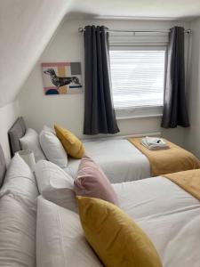 MaghullPark View House的一间卧室设有两张床和窗户。