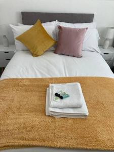 MaghullPark View House的一张带毛巾和枕头的白色床