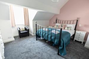科尼斯顿Stunning Holiday Home - Puddleduck - Centre of Coniston的一间卧室配有一张床和一把椅子