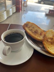 坎皮纳斯Pousada viracopos的盘子里的咖啡和两片烤面包