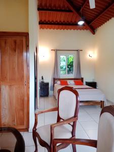 圣达菲Hotel Anachoreo的一间卧室设有两张床、一把椅子和一个窗户。