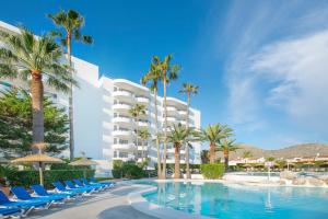 阿尔库迪亚港Alcudia Beach Apartments的一个带椅子和棕榈树的游泳池的度假酒店