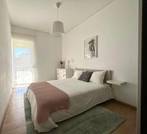 里斯本Olivais Spacious Apartment near airport的白色的卧室设有一张大床和一个窗户