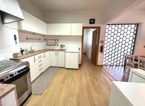 里斯本Olivais Spacious Apartment near airport的厨房铺有木地板,配有白色橱柜。