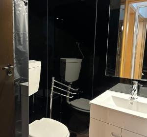 里斯本Olivais Spacious Apartment near airport的黑色浴室设有卫生间和水槽