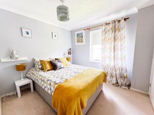 SendBeautiful apartment in Guildford with parking的一间卧室配有一张黄色毯子床