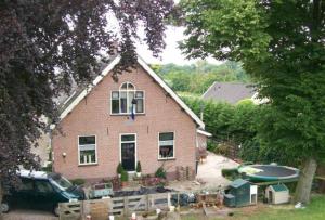 莱克凯尔克Het Boenhok logies的前面有停车位的房子