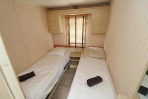 WolphaartsdijkDe Zuidvliet Chalet 3的小型客房 - 带2张床和窗户