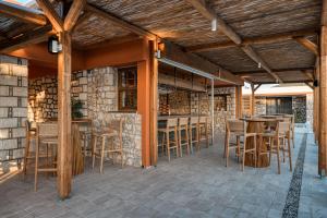 ValanidorachiTrinity Design Suites的庭院设有带木椅和桌子的酒吧