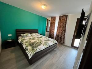 图尔达Sunset Expanse的一间卧室设有一张床和绿色的墙壁