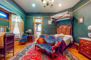 斯普林菲尔德Clarkson W Freeman House的一间卧室配有天蓬床和蓝色椅子