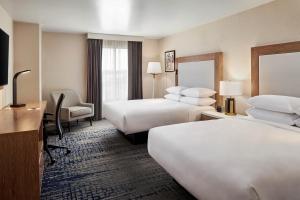 桑兹顿Sheraton Richmond Airport Hotel的酒店客房配有两张床和一张书桌