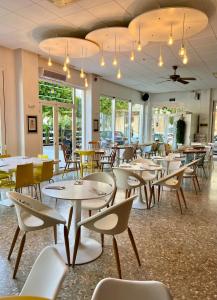 圣安东尼奥Aparthotel Boutique Poniente Playa的餐厅设有桌椅和窗户。