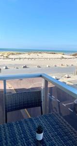 马翁普拉日堡Studio Entre MER ET DUNES avec balcon vue laterale MER 50m plage pour 3 pers wifi ménage compris的海滩阳台的桌椅