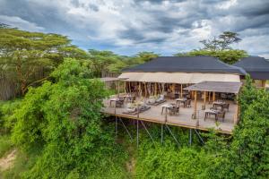 马赛马拉JW Marriott Masai Mara Lodge的享有建筑空中美景,甲板上配有桌椅