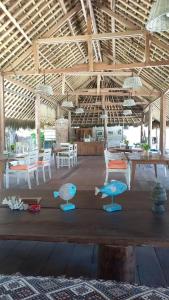 RuaRua Beach Resort Sumba的配有桌椅和木制长凳的房间