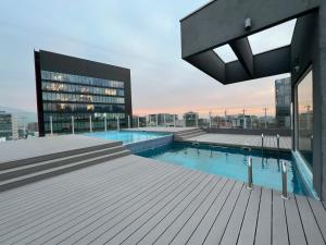 圣地亚哥Oceana Suites Capital, vista a la ciudad的建筑物屋顶上的游泳池