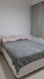 维拉维尔哈Jockey Family_Villaggio di Piazza的一张带灰色毯子和窗户的床