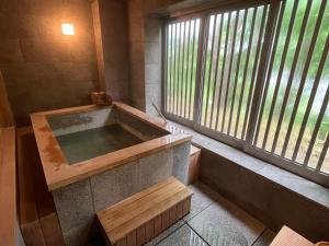 Jozankei廚翠山旅館的窗户客房内的浴缸