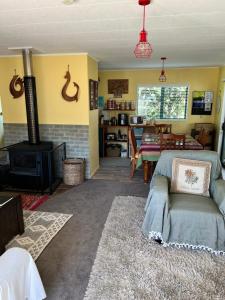 图克劳海滩Karikari Lodge的带沙发和炉灶的客厅