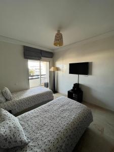 阿加迪尔Luxueux appartement à la Marina d’agadir的酒店客房设有两张床和电视。