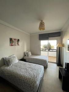 阿加迪尔Luxueux appartement à la Marina d’agadir的酒店客房设有两张床和窗户。