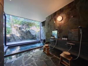 伊东Doggy's Izujogasaki的浴室中间设有大窗户的房间
