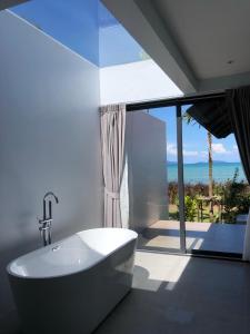 麦岛Little Moon Villa的带浴缸的浴室,享有海景。