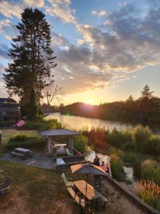 坎贝尔河Campbell River Lodge的一群人坐在雨伞下,靠近一条河流