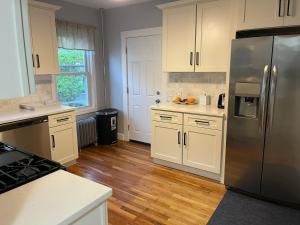 波士顿Boston Luxury Condo Style Rooms的厨房配有白色橱柜和不锈钢冰箱
