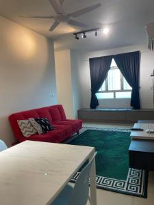峇六拜Spice Arena Guesthouse的客厅配有红色沙发和绿色地毯。