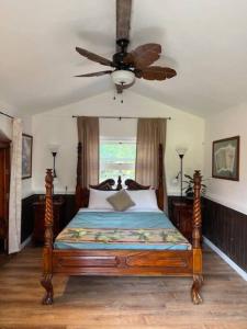 凯阿奥The Red Cottage and Hawaiian Pond Garden Paradise!的一间卧室配有一张带吊扇的床