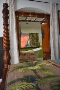 凯阿奥The Red Cottage and Hawaiian Pond Garden Paradise!的一间带浴缸和镜子的卧室