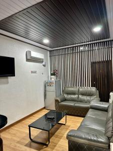 加央Kangar Hotel Sdn Bhd的带沙发和冰箱的客厅