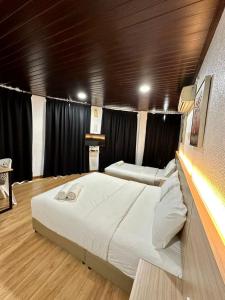 加央Kangar Hotel Sdn Bhd的一张大床,位于带黑色窗帘的房间