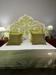 克鲁格斯多普Rabbit Hole Hotel的一间卧室配有一张带绿色和黄色枕头的大床