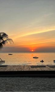 南威My Blue Hotel Zanzibar的海上的日落,在水中乘船