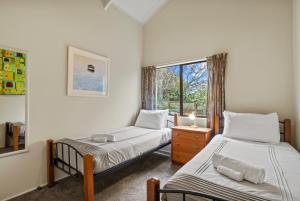 陶波Greenhaven with wi-fi的一间卧室设有两张床和窗户。