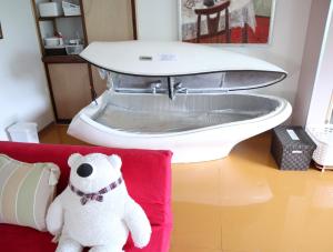 立山町Pension Alba - Vacation STAY 70965v的坐在红色沙发上的白泰迪熊