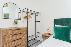 文特诺Stunning 3 Bed Apt With Countryside Views & Parking - Ideal For Families, Groups & Business Stays - Close To Ventnor, Shanklin & Sandown的一间卧室配有一张带镜子和梳妆台的床