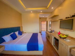 博卡拉Majestic Lake Front Hotel & Suites的一间卧室配有一张大床和一台平面电视