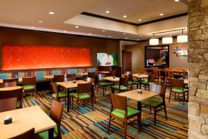 休斯顿休斯顿洲际机场费尔菲尔德客栈的餐厅设有木桌和绿色椅子